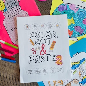 May include: A white booklet with the title "Color, Cut & Paste 2" in black text. The booklet has colorful images of a blender, a cupcake, a globe, a paintbrush, scissors, and glue. There are also smaller images of a castle, a house, a car, and a gumball machine.