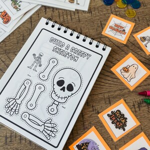 Pu&ograve; includere: Un libro di attivit&agrave; di Halloween stampabile in bianco e nero con il titolo "Costruisci uno scheletro inquietante". Il libro include uno scheletro con parti mobili da ritagliare e assemblare.