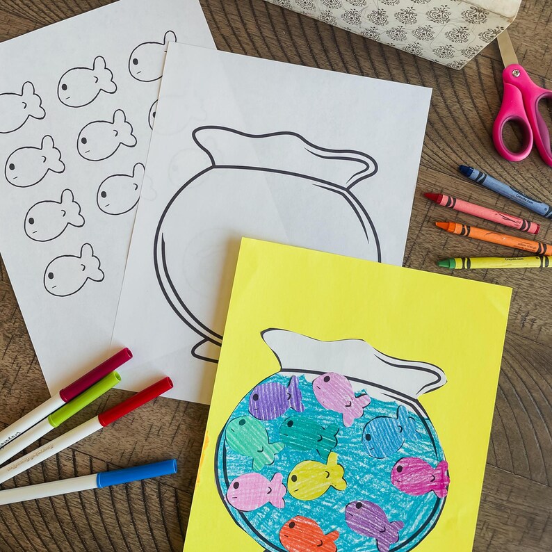 Op de afbeelding: Een knutselproject voor kinderen om een ​​viskom te maken met kleurrijke vissen. Het project bevat een blanco viskomsjabloon, een gele viskom met kleurrijke vissen en kleurpotloden of stiften.