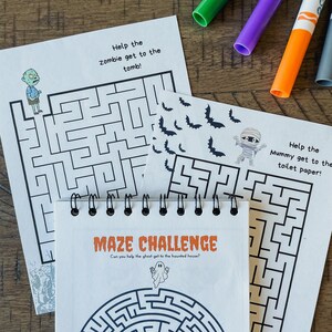 Pu&ograve; includere: Tre fogli di attivit&agrave; di labirinto a tema Halloween. Il primo foglio presenta un labirinto di zombie con il testo "Help the zombie get to the tomb!" Il secondo foglio presenta un labirinto di mummie con il testo "Help the Mummy get to the toilet paper!" Il terzo foglio presenta un labirinto di fantasmi con il testo "Maze Challenge: Can you help the ghost get to the haunted house?"