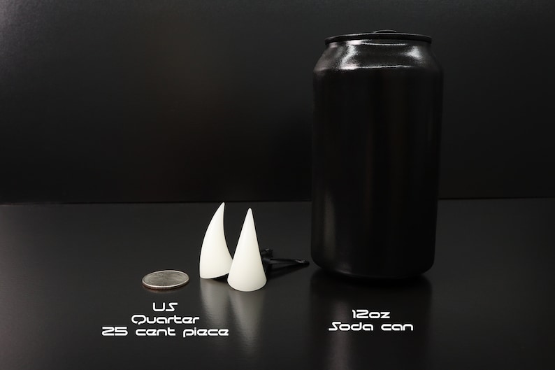 May include: A black soda can, two white cone-shaped objects, and a U.S. quarter are displayed on a black surface. The soda can is labeled "12oz Soda can". The quarter is labeled "U.S. Quarter 25 cent piece".