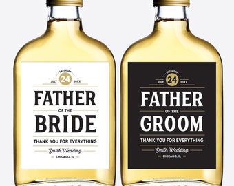 May include: Two clear glass bottles with gold lids and black and white labels. The labels have the text "Father of the Bride" and "Father of the Groom" with the date "July 24, 20XX" and the text "Smith Wedding - Chicago, IL".