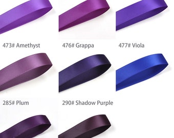 Puede incluir: Nueve muestras de cinta de raso en varios tonos de morado. Cada cinta está etiquetada con un número y un nombre de color, incluyendo "Purple", "Ultra Violet", "Regal Purple", "Amethyst", "Grappa", "Viola", "Plum" y "Shadow Purple".