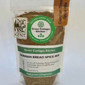 May include: A clear plastic bag filled with a brown spice blend. The bag has a green label with the text "Green Cottages Kitchen" and "German Bread Spice Mix". The label also includes the text "A mix of Caraway, Anise, Fennel and Coriander spice to add to your bread dough. Bread Baking" and the website address "shop.green-cottages.com".