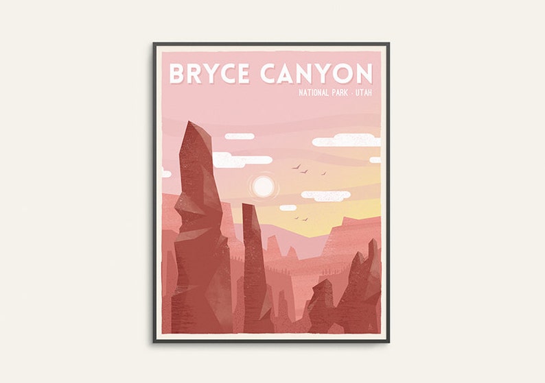 May include: Framed art print featuring a stylized illustration of Bryce Canyon National Park in Utah. The artwork showcases towering red rock formations under a pink and yellow sunset sky, with the text "BRYCE CANYON" at the top.