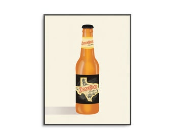May include: A brown glass bottle of Ziegen Bock Texas Amber Lager beer with a black label featuring a stylized outline of the state of Texas. The label also includes the brewery's name and the words "Texas Amber Lager".
