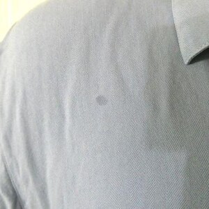 May include: A light blue long-sleeved shirt with a herringbone pattern.