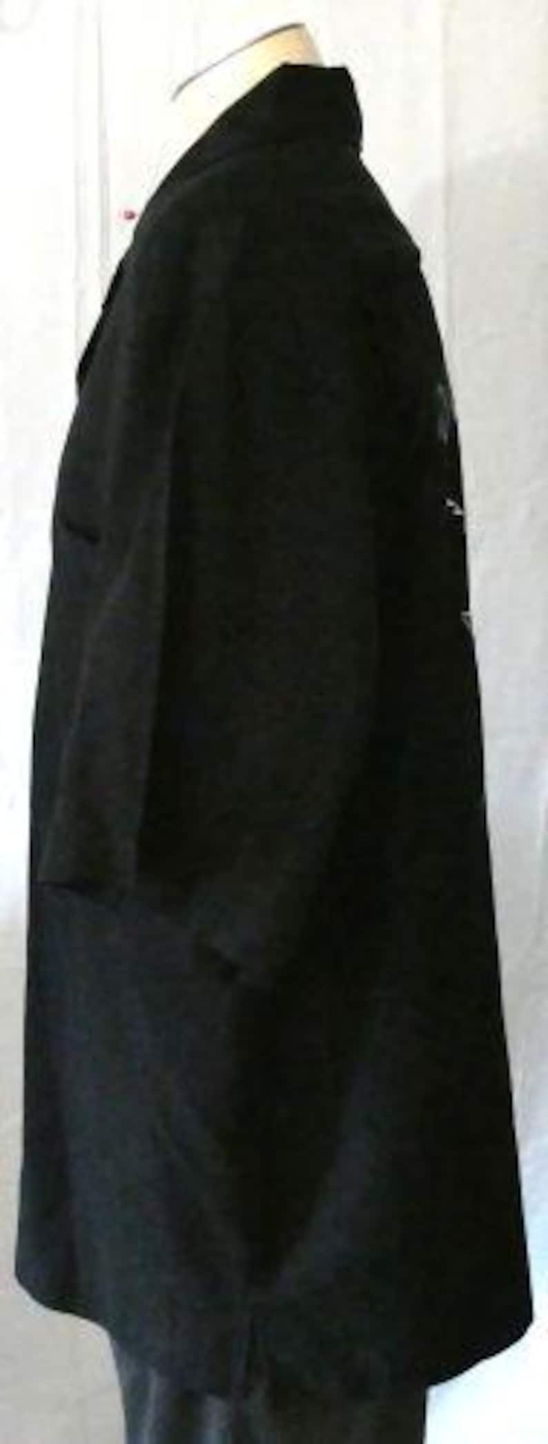 May include: A black short-sleeved blazer with a notched collar. The blazer has a classic design with a button closure and a tailored fit. The fabric appears to be a medium-weight material, suitable for various occasions. The blazer is displayed on a mannequin.