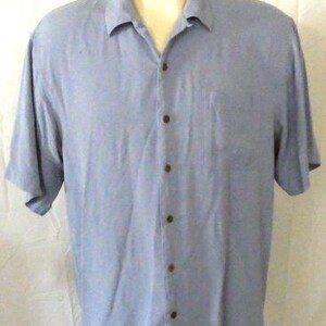 May include: A light blue short-sleeved button-down shirt with a single chest pocket.