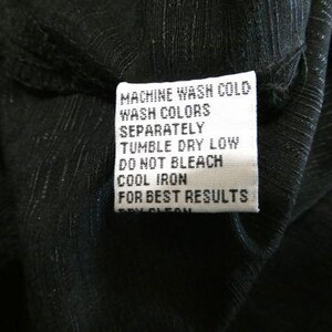 May include: Close-up of a black garment with a white care label. The label reads "MACHINE WASH COLD, WASH COLORS SEPARATELY, TUMBLE DRY LOW, DO NOT BLEACH, COOL IRON, FOR BEST RESULTS."