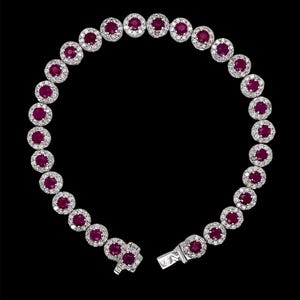 May include: A white gold bracelet with a row of round red rubies surrounded by smaller diamonds.