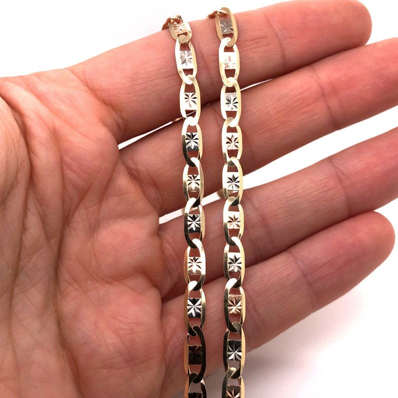 May include: A gold chain necklace with a diamond-cut design. The chain is made of 10k gold and has a polished finish.