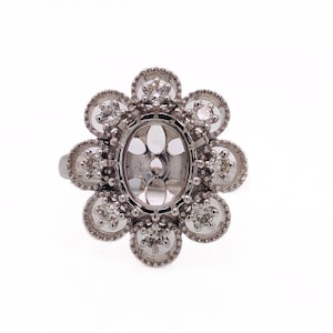 May include: A silver ring setting with a floral design featuring six round accents with small diamonds. The center of the ring is an oval-shaped setting for a larger stone.