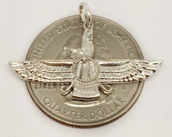May include: Silver pendant charm featuring a detailed depiction of the winged disc, a symbol of ancient Persia, known as the Faravahar. The pendant is shown next to a US quarter for size comparison.