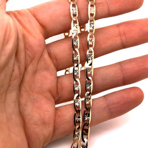 May include: A gold chain necklace with a diamond-cut design. The chain is made of two strands of gold, one with a polished finish and the other with a matte finish.