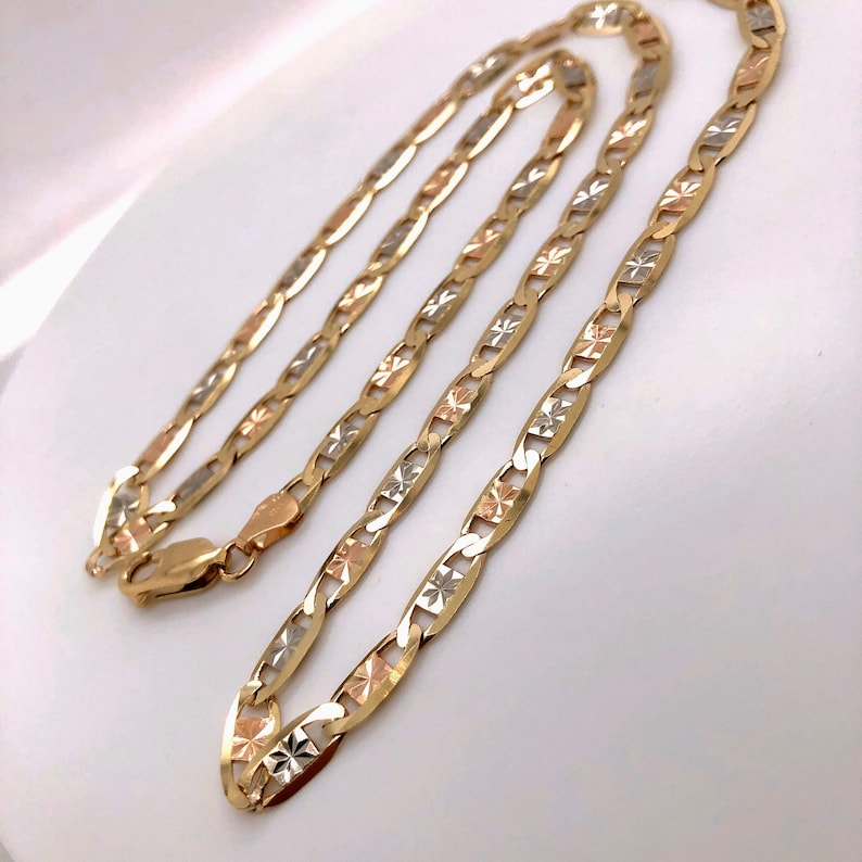 May include: A gold chain necklace with a mariner link design. The chain is made of three different colors of gold: yellow, white, and rose.