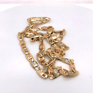 May include: A gold chain necklace with a mariner link design. The chain is made of three different colors of gold: yellow, white, and rose.
