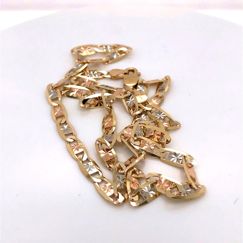 May include: A gold chain necklace with a mariner link design. The chain is made of three different colors of gold: yellow, white, and rose.