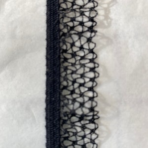 May include: Black lace trim with a delicate floral pattern. The trim is about 1 inch wide and has a soft, flexible texture.