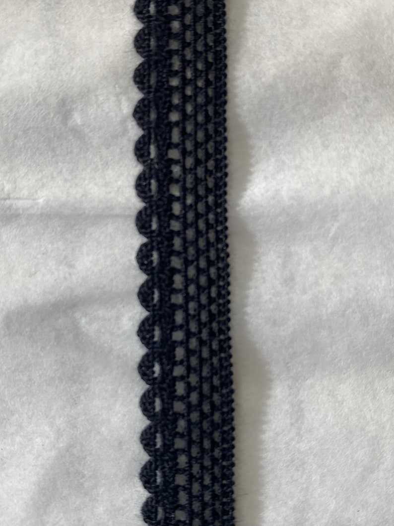 May include: Black lace trim with a scalloped edge.