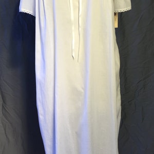 May include: White cotton nightgown with a lace collar and short sleeves. The gown has a satin ribbon tied at the neck.