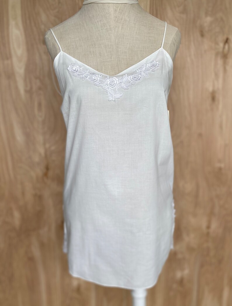 K&ouml;nnte beinhalten: Wei&szlig;es Baumwoll-Schlafkleid mit zarter Blumenstickerei am Ausschnitt.