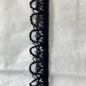 May include: Black lace trim with a scalloped edge.