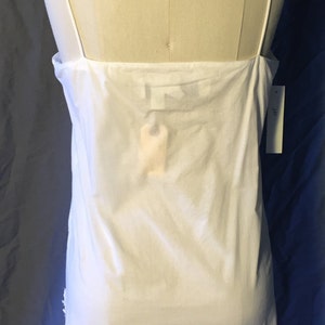 K&ouml;nnte beinhalten: Wei&szlig;es, &auml;rmelloses Schlupfkleid mit d&uuml;nnen Tr&auml;gern. Das Kleid ist aus einem leichten Stoff gefertigt und hat ein schlichtes, klassisches Design.