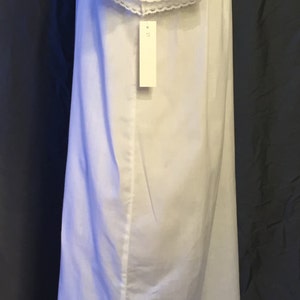 May include: White cotton nightgown with lace trim around the neckline and sleeves. The nightgown has a tag that says "M" on it.