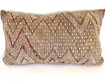 May include: A rectangular brown and white patterned throw pillow with a geometric design.