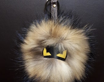 Porte-clés en fourrure de raton laveur face à un monstre. Porte-clés pompon en fourrure véritable avec masque et sangle en cuir véritable.