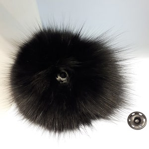 May include: Black faux fur pom pom with a black snap button.