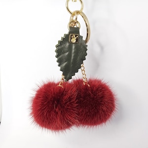 Porte-clés pompon avec breloques en vison bordeaux avec longue chaîne et feuille en cuir véritable.