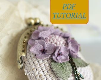 May include: A crocheted coin purse with a floral design. The purse is white with a purple flower and green leaves. The purse has a metal clasp and a beaded tassel.