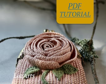 May include: A pink crocheted coin purse with a rose-shaped flower and green leaves. The purse has a metal clasp and the text "LozArts" is visible. The image includes the text "PDF TUTORIAL".