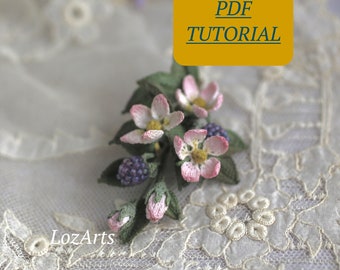 May include: A close-up of a delicate crocheted flower brooch with pink petals, green leaves, and purple berries. The brooch is resting on a white lace fabric. The text "PDF TUTORIAL" is visible in a yellow box.