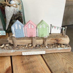 Handmade clay beach huts on driftwood
