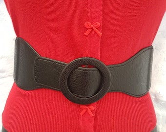 Ceinture élastique noire avec grande boucle circulaire.