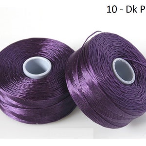 Pode incluir: Dois carret&eacute;is de fio roxo escuro, etiquetados como "10 - Dk Purple".