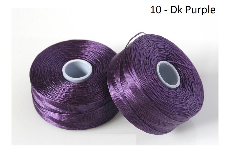 Pode incluir: Dois carret&eacute;is de fio roxo escuro, etiquetados como "10 - Dk Purple".