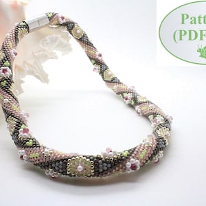 May include: A beaded necklace with a pink, gray, and green color scheme. The necklace is made with small beads and has a floral pattern. The necklace is on a white background.