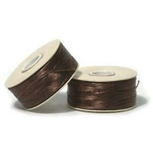 May include: Two spools of brown waxed cord, ideal for jewelry making or crafts. The cord is tightly wound on white cardboard spools. The spools are positioned on a white background, with one slightly angled towards the viewer.