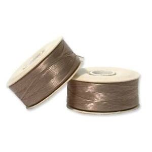 May include: Two spools of brown nylon thread are displayed against a white background. The thread is tightly wound on white spools. The nylon thread has a slight sheen, suggesting a smooth texture. The spools are positioned at different angles.