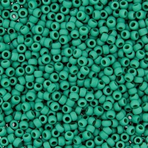 K&ouml;nnte beinhalten: Eine Nahaufnahme von einer gro&szlig;en Menge an tealgr&uuml;nen Perlen. Die Perlen sind klein und rund und alle gleich gro&szlig;.