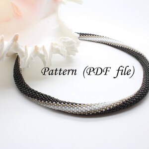 May include: A black and white beaded necklace with a gradient pattern. The necklace is lying on a white surface next to a seashell. The text "Pattern (PDF file)" is visible in the image.