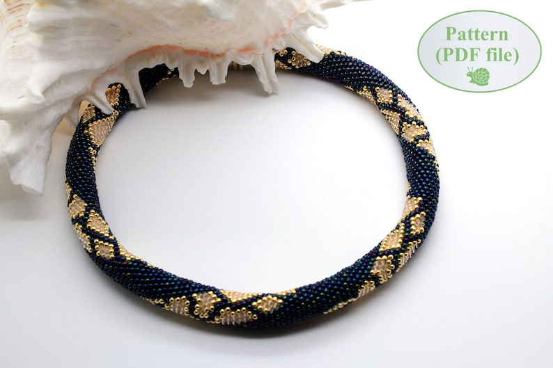 May include: A dark blue and gold beaded necklace with a geometric pattern. The necklace is displayed on a white background.