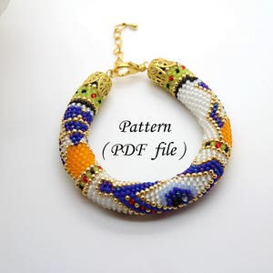 Peut inclure: Un bracelet en perles colorées avec un fermoir doré. Le bracelet présente un motif géométrique avec des perles blanches, bleues, orange, jaunes et vertes. Le texte "Pattern (PDF file)" est visible sur l'image.