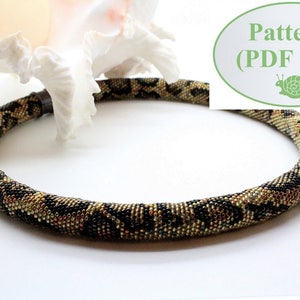 May include: A beaded necklace with a black, gold, and brown snake skin pattern. The necklace is lying on a white surface. The text "Pattern (PDF file)" is visible in the image.
