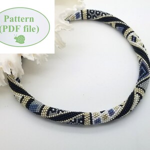 May include: A black, white, silver, and blue beaded necklace with a geometric pattern. The necklace is made of small beads and is about 18 inches long.