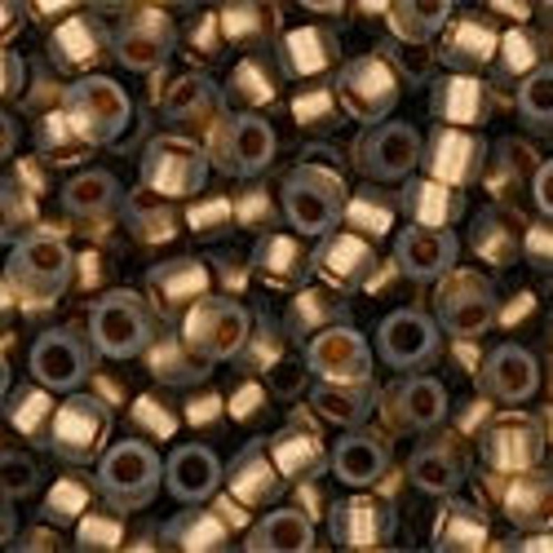 May include: A large pile of small, gold-colored metal beads. The beads are cylindrical in shape with a hole in the center.